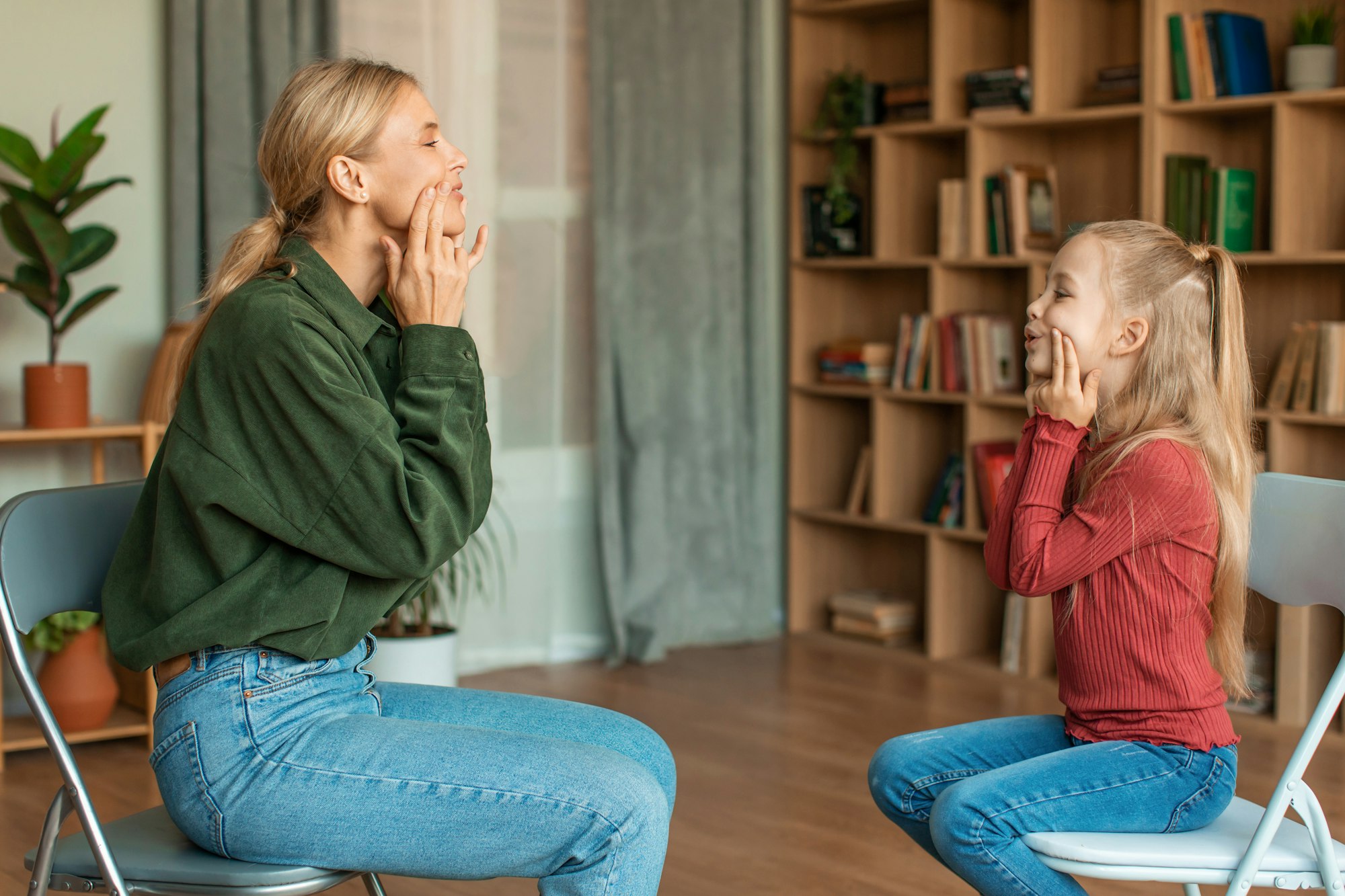 Speech practice. Girl preschooler training with professional speech specialist, repeating oral